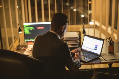 person sitting at desk working on laptop