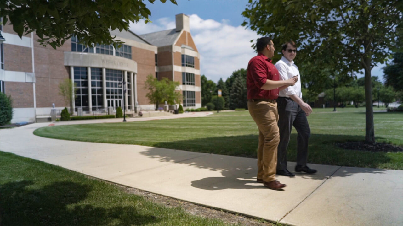 campus building with two people looking towards something