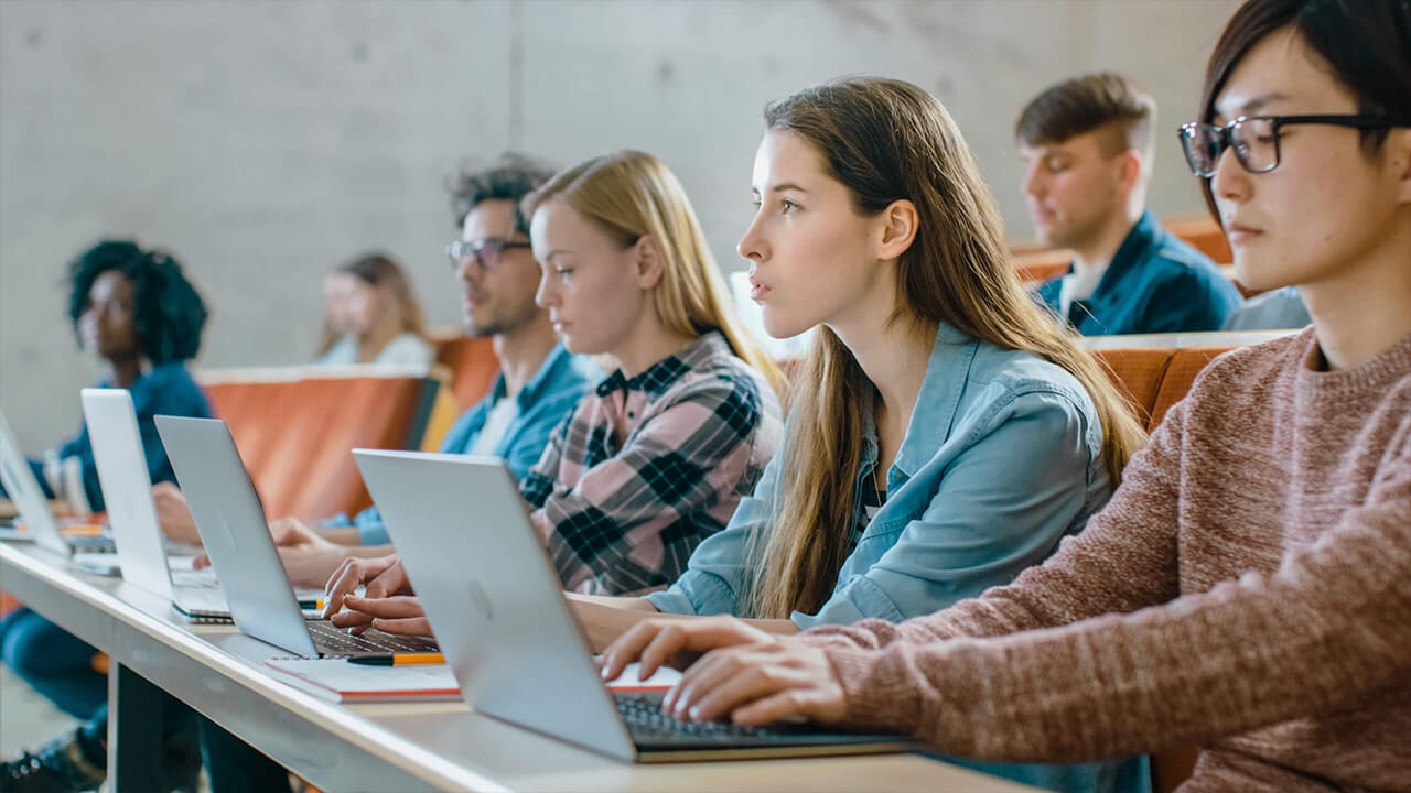 students in a classroom with their laptops